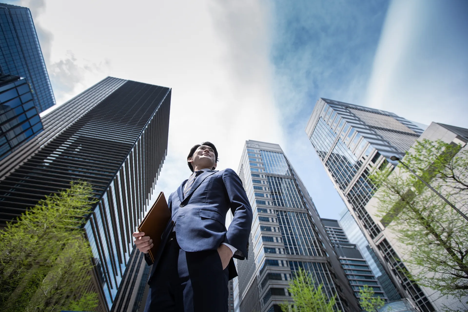オフィスビルの間にいるスーツ姿の男性